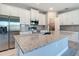 Kitchen showcasing a large granite island with stainless steel sink, and white cabinets, perfect for meal prep and entertaining at 2423 Sadnet Ln, North Port, FL 34286