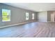 Spacious living area with wood-look flooring, neutral paint, and ample natural light from three large windows at 2423 Sadnet Ln, North Port, FL 34286