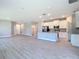 Open floor plan with modern kitchen featuring white cabinets, stainless steel appliances, and a large center island at 2423 Sadnet Ln, North Port, FL 34286