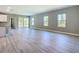 Bright, open-concept living area features modern gray walls, light wood floors, and large windows with plenty of natural light at 2423 Sadnet Ln, North Port, FL 34286