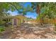 Backyard view showing the home's exterior, covered patio, shed, and wooden privacy fence at 107 W Woodlawn Ave, Tampa, FL 33603