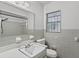 Bathroom with a big mirror and a window, the walls are tiled, and there is a sink and a toilet at 107 W Woodlawn Ave, Tampa, FL 33603