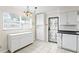 Kitchen with a large window, white cabinetry and countertops, and a security door at 107 W Woodlawn Ave, Tampa, FL 33603