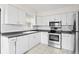 Bright kitchen featuring stainless steel appliances, white cabinets, and tile backsplash at 107 W Woodlawn Ave, Tampa, FL 33603