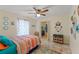 Inviting bedroom featuring a ceiling fan, vibrant textiles, and access to a walk-in closet at 5188 Elwood Rd, Spring Hill, FL 34608