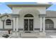 Close-up view of the home's front entrance, showcasing decorative double doors, pillars, and carefully placed garden statues at 5188 Elwood Rd, Spring Hill, FL 34608