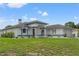 Beautiful single-story home with white stucco, arched windows, double door entry and manicured front lawn at 5188 Elwood Rd, Spring Hill, FL 34608