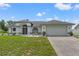 Charming single-story home featuring white exterior, gray accents, well-maintained lawn, and an attached two-car garage at 5188 Elwood Rd, Spring Hill, FL 34608