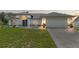Charming single-story home featuring white exterior, gray accents, well-maintained lawn, and an attached two-car garage at 5188 Elwood Rd, Spring Hill, FL 34608