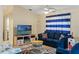Comfortable living room with a blue sofa, tv, tile floor and nautical themed decorations at 5188 Elwood Rd, Spring Hill, FL 34608