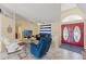 Open living room with light walls, tile floors, comfortable blue sofa and red front door at 5188 Elwood Rd, Spring Hill, FL 34608