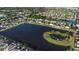Aerial view of house located by a big pond that has an island in a well-maintained neighborhood at 1739 Broad Winged Hawk Dr, Ruskin, FL 33570