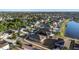 Aerial view of a two-story home with lush lawn and landscaping in a lakefront community, with view of trees and lawns at 1739 Broad Winged Hawk Dr, Ruskin, FL 33570