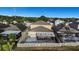 Aerial view of a backyard with a screened lanai, patio, and white picket fence at 1739 Broad Winged Hawk Dr, Ruskin, FL 33570