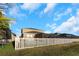 A white fence lines the backyard, providing a view of the screened-in lanai at 1739 Broad Winged Hawk Dr, Ruskin, FL 33570
