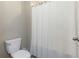 Clean bathroom with a toilet, tile floor, and a shower with a curtain at 1739 Broad Winged Hawk Dr, Ruskin, FL 33570