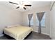 Bedroom with ceiling fan, hard wood floors, and windows with gray curtains at 1739 Broad Winged Hawk Dr, Ruskin, FL 33570