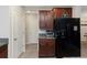 Kitchen features dark brown cabinets, a black refrigerator, and neutral walls at 1739 Broad Winged Hawk Dr, Ruskin, FL 33570
