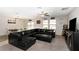 Inviting living room with leather sectional, tiled floors, and natural light from the large window at 1739 Broad Winged Hawk Dr, Ruskin, FL 33570