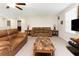 Living room with carpet, leather couches, ceiling fan, and a stone coffee table at 1739 Broad Winged Hawk Dr, Ruskin, FL 33570