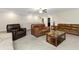 Spacious living room with leather seating, ceiling fan, and a stone coffee table at 1739 Broad Winged Hawk Dr, Ruskin, FL 33570