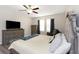 Comfortable primary bedroom with a ceiling fan, dresser, and large windows for natural light and views at 1739 Broad Winged Hawk Dr, Ruskin, FL 33570