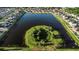 An aerial view showcases a center island pond with lush greenery in a well-manicured neighborhood at 1739 Broad Winged Hawk Dr, Ruskin, FL 33570