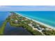 Stunning aerial view showcases the waterfront property, sandy beach, and serene lagoon at 3389 Pennyroyal Rd, Port Charlotte, FL 33953