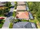 Aerial view of neighborhood homes with well-manicured lawns, tile roofs, and screened pools at 3389 Pennyroyal Rd, Port Charlotte, FL 33953