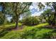 Lush backyard featuring mature landscaping, providing privacy and a serene outdoor space at 3389 Pennyroyal Rd, Port Charlotte, FL 33953