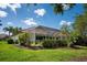 Expansive backyard features a screened-in lanai, mature trees, and verdant lawn at 3389 Pennyroyal Rd, Port Charlotte, FL 33953