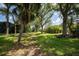 Expansive backyard with mature trees and verdant lawn offers space for outdoor activities at 3389 Pennyroyal Rd, Port Charlotte, FL 33953