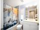 Well-lit bathroom with a tub, shower with decorative curtain, and white vanity at 3389 Pennyroyal Rd, Port Charlotte, FL 33953