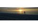 Peaceful ocean scene with the silhouette of a Personal wading into the tranquil water at sunset at 3389 Pennyroyal Rd, Port Charlotte, FL 33953