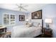 Light-filled bedroom features a queen bed with neutral bedding and a ceiling fan at 3389 Pennyroyal Rd, Port Charlotte, FL 33953