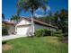 Well-maintained home featuring a tile roof, lush landscaping, and an attached two-car garage at 3389 Pennyroyal Rd, Port Charlotte, FL 33953