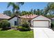 Charming single-story home boasts lush landscaping, a two-car garage, and a clay tile roof at 3389 Pennyroyal Rd, Port Charlotte, FL 33953