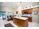 Bright kitchen with wooden cabinetry, large island, and view to the outside patio at 3389 Pennyroyal Rd, Port Charlotte, FL 33953