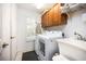 Bright laundry room features a washer, dryer, utility sink and storage cabinets at 3389 Pennyroyal Rd, Port Charlotte, FL 33953