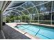 Relaxing screened-in pool area with brick patio and dining set provides a perfect outdoor escape at 3389 Pennyroyal Rd, Port Charlotte, FL 33953