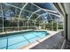 Screened-in pool offers a private outdoor space surrounded by mature landscaping at 3389 Pennyroyal Rd, Port Charlotte, FL 33953