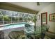 Screened-in patio with table and chairs overlooking a private pool and lush greenery at 3389 Pennyroyal Rd, Port Charlotte, FL 33953