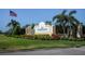 Community entrance sign featuring lush landscaping and an American flag waving proudly at 3389 Pennyroyal Rd, Port Charlotte, FL 33953