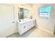 Bright bathroom featuring a double sink vanity, a large mirror, and a window at 2370 Allsup Ter, North Port, FL 34286