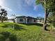 A spacious backyard featuring lush green grass and the rear exterior of the home at 4097 Feather Ter, North Port, FL 34286