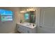 Modern bathroom with double sinks, a large mirror, and ample natural light at 4097 Feather Ter, North Port, FL 34286