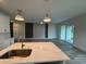 Bright, open-concept kitchen and living area with modern lighting and an island at 4097 Feather Ter, North Port, FL 34286