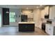 Modern kitchen with white cabinets, stainless steel appliances, and a dark island at 4097 Feather Ter, North Port, FL 34286