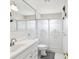 Bathroom featuring frosted glass shower doors, large mirror, and white cabinets for storage at 2401 Ecuadorian Way # 45, Clearwater, FL 33763