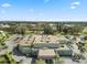 Aerial view of building with mature trees, parking, and covered entry with surrounding landscaping at 2401 Ecuadorian Way # 45, Clearwater, FL 33763